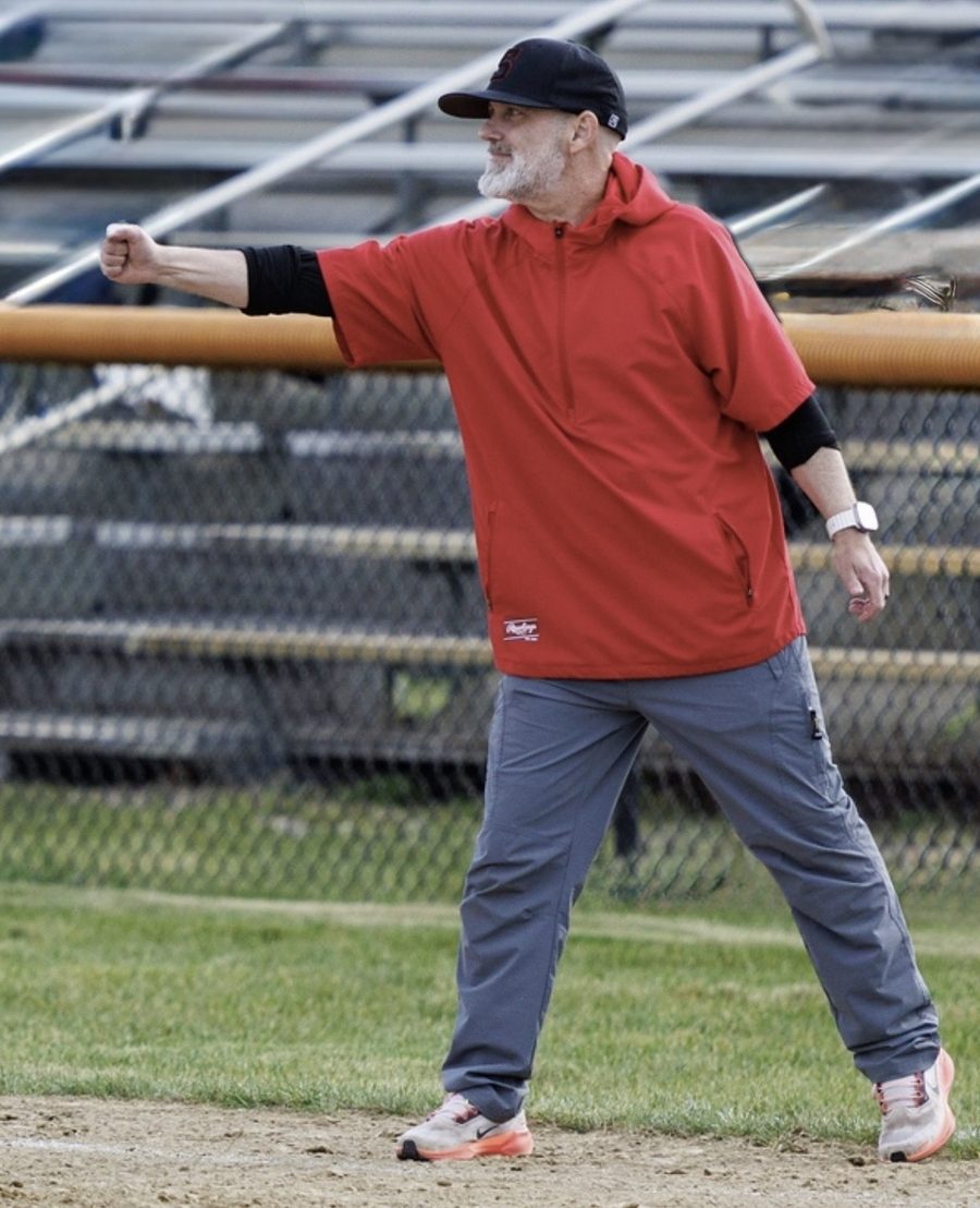 Coach Andy at first base, holding out a fist bump